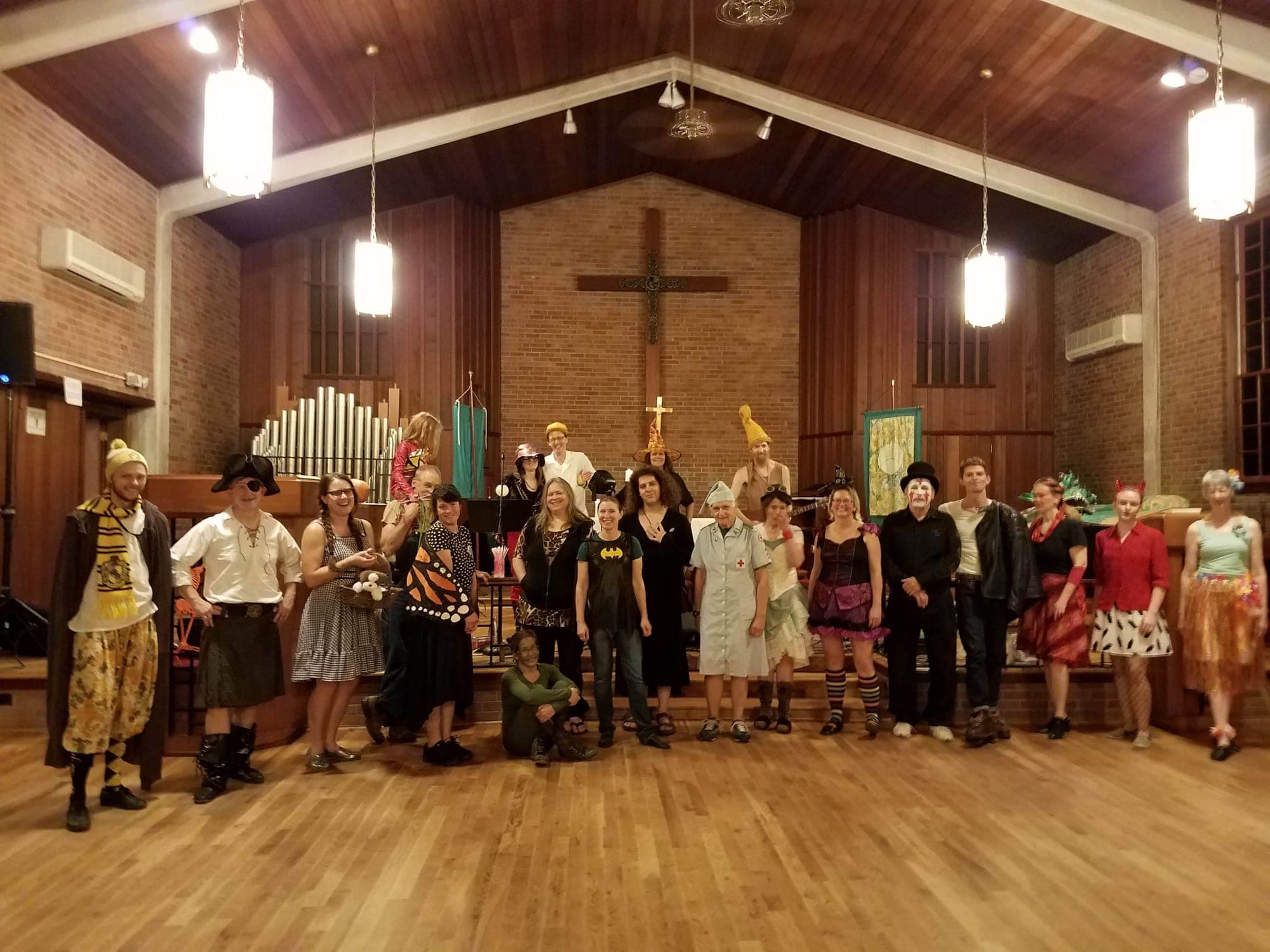 Dancers in costumes lined up for a group photo at a Halloween dance